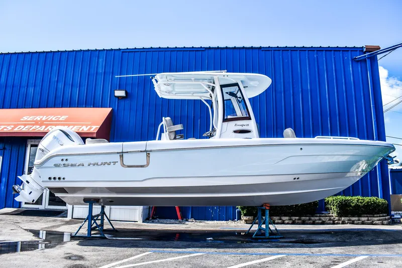 Slide: The Image of 2025 Sea Hunt Escape 25 boat displayed outside a service department. - 0