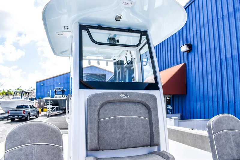 Slide: The Image of 2025 Sea Hunt Escape 25 boat at a marina with blue buildings. - 12