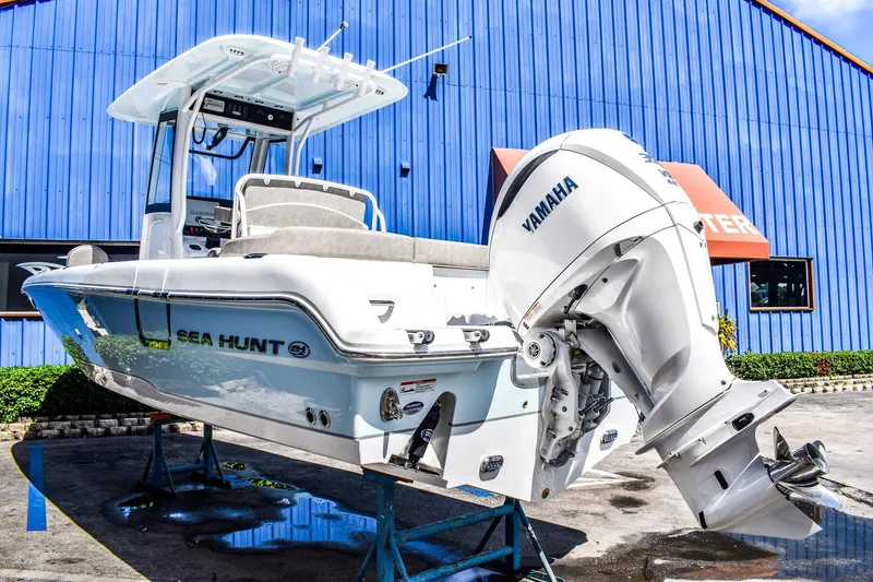 Slide: The Image of 2025 Sea Hunt Escape 25 boat with Yamaha outboard motor on display. - 2