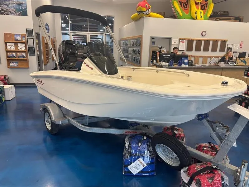 Slide: The Image of 2025 Boston Whaler 130 Super Sport boat displayed in showroom on trailer. - 1