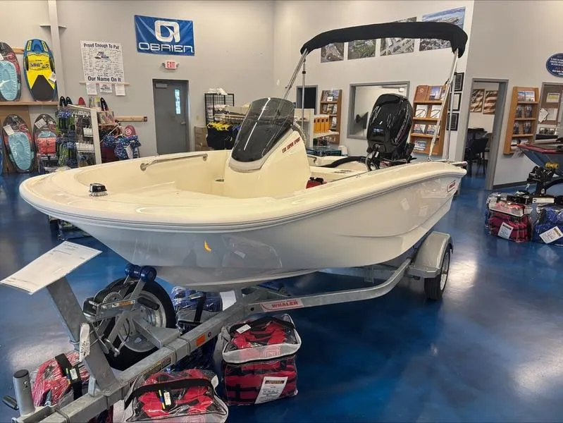 Slide: The Image of 2025 Boston Whaler 130 Super Sport boat displayed in showroom on trailer. - 3