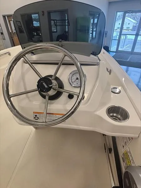 Slide: The Image of 2025 Boston Whaler 130 Super Sport boat dashboard with steering wheel and gauges. - 9