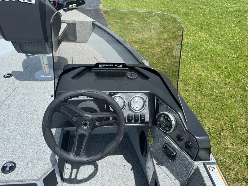 Slide: The Image of 2025 Lund 1775 Adventure SS boat dashboard with steering wheel and gauges. - 9
