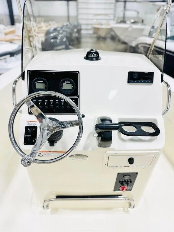 Slide: The Image of 2025 Scout 195 Sportfish boat console with steering wheel and control panel. - 3
