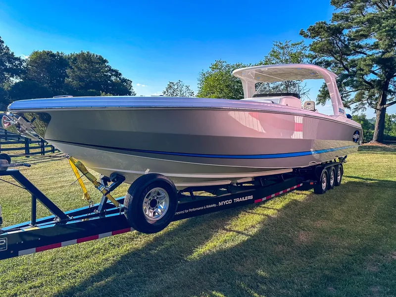 Slide: The Image of 2021 Cigarette 39 GTS boat on trailer in grassy area with trees. - 16