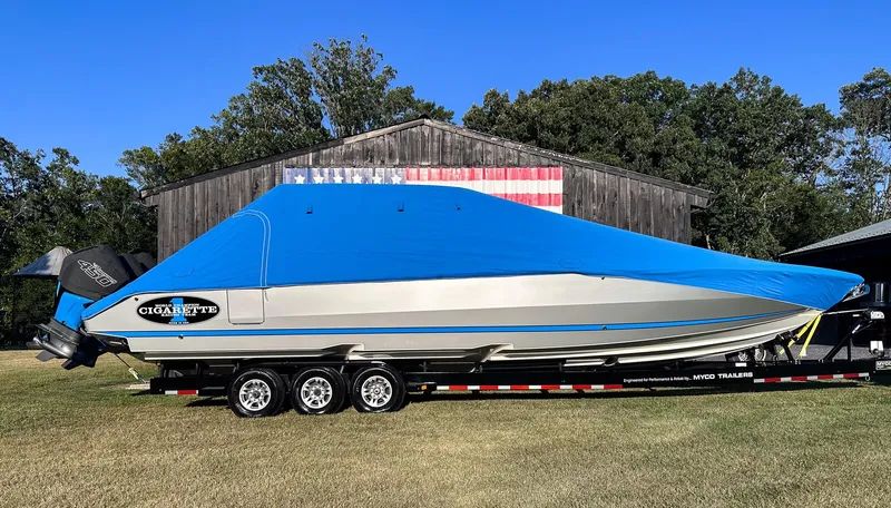 Slide: The Image of 2021 Cigarette 39 GTS boat with blue cover on trailer, parked outdoors. - 20