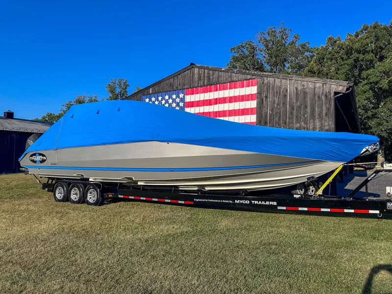 Slide: The Image of 2021 Cigarette 39 GTS boat with blue cover on trailer, American flag backdrop. - 21