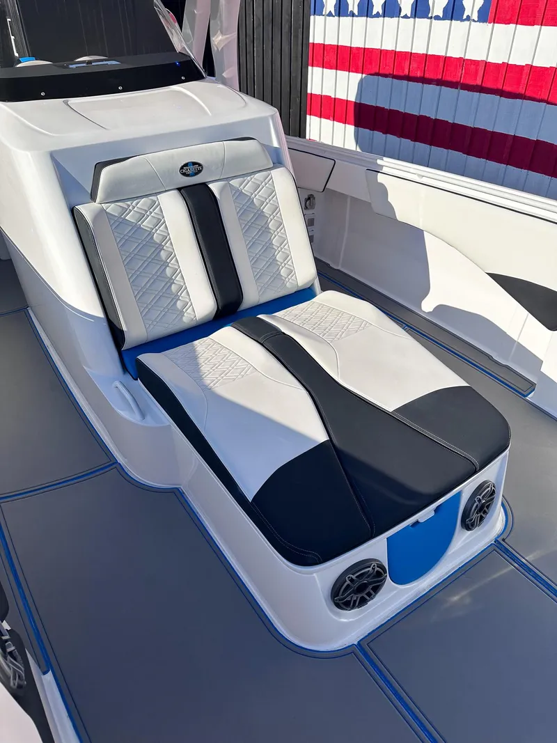 Slide: The Image of 2021 Cigarette 39 GTS boat interior with luxury seating and American flag backdrop. - 8