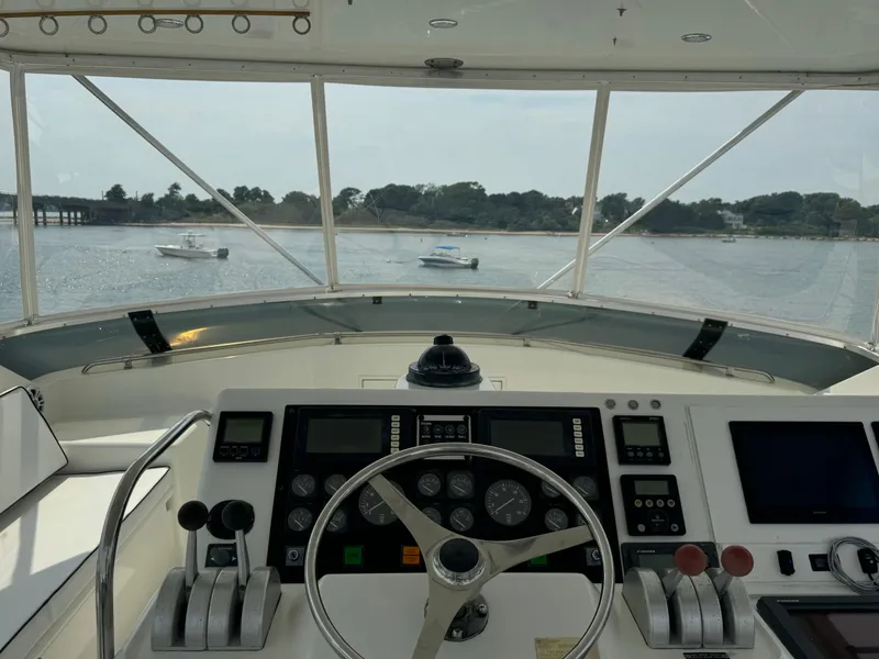 Slide: The Image of Cockpit view of 1994 Hatteras 54 Convertible yacht with scenic waterway and boats. - 21
