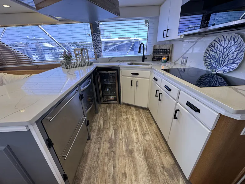 Slide: The Image of Modern kitchen interior on 1994 Hatteras 54 Convertible yacht with sleek countertops and appliances. - 23