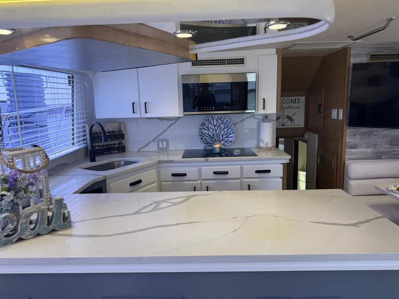 Slide: The Image of Modern kitchen interior of 1994 Hatteras 54 Convertible yacht with sleek countertops and appliances. - 25
