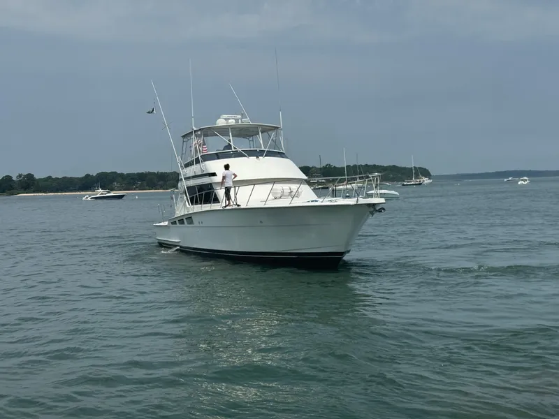 Slide: The Image of 1994 Hatteras 54 Convertible yacht cruising on calm waters. - 5