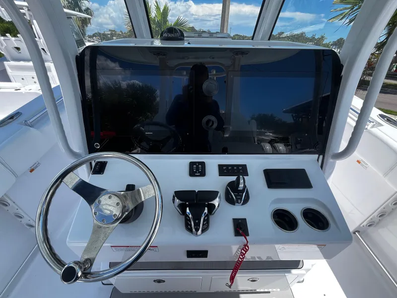 Slide: The Image of 2024 Sportsman 322 OPEN CC boat helm with steering wheel and control panel. - 11