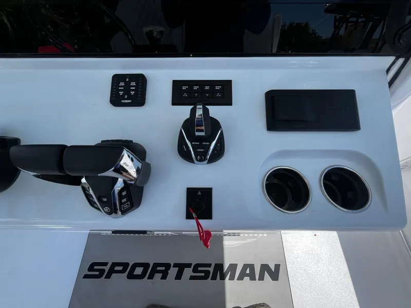 Slide: The Image of Control panel of 2024 Sportsman 322 OPEN CC boat with throttle and cup holders. - 12