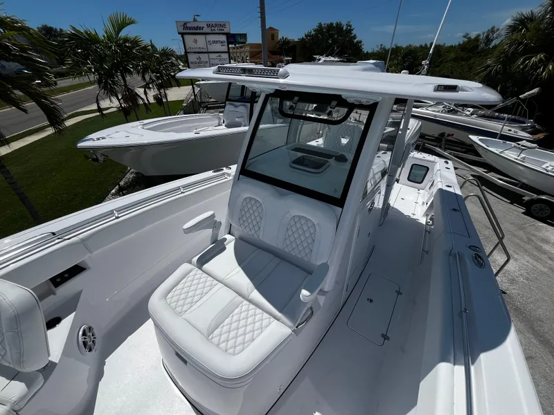 Slide: The Image of 2024 Sportsman 322 OPEN CC center console boat with white seating and modern design. - 23