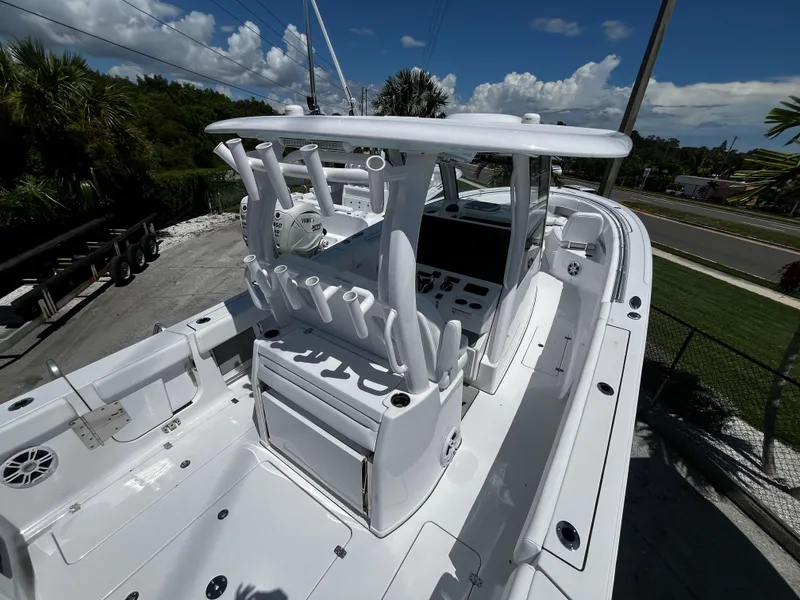 Slide: The Image of 2024 Sportsman 322 OPEN CC boat, center console, white exterior, docked, sunny day. - 24