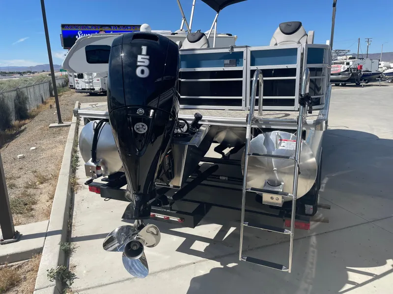 Slide: The Image of 2025 South Bay 224FCRLE pontoon boat with 150 HP outboard motor and ladder. - 2