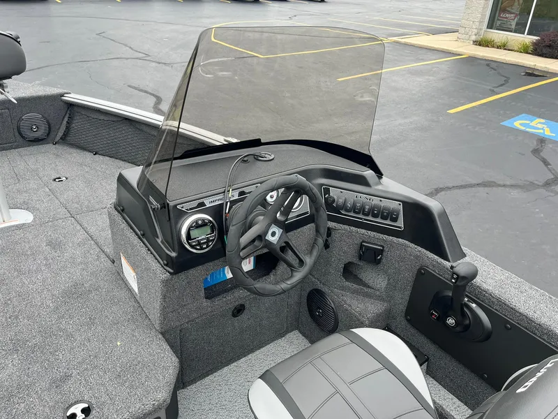 Slide: The Image of 2025 Lund 1875 Impact XS SS boat interior with steering wheel and dashboard. - 11