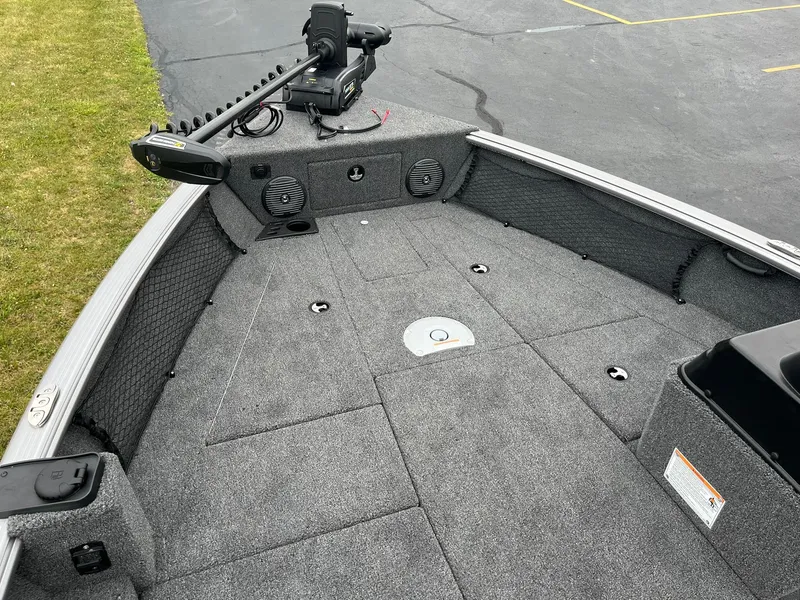 Slide: The Image of 2025 Lund 1875 Impact XS SS boat deck with trolling motor and carpeted surface. - 16