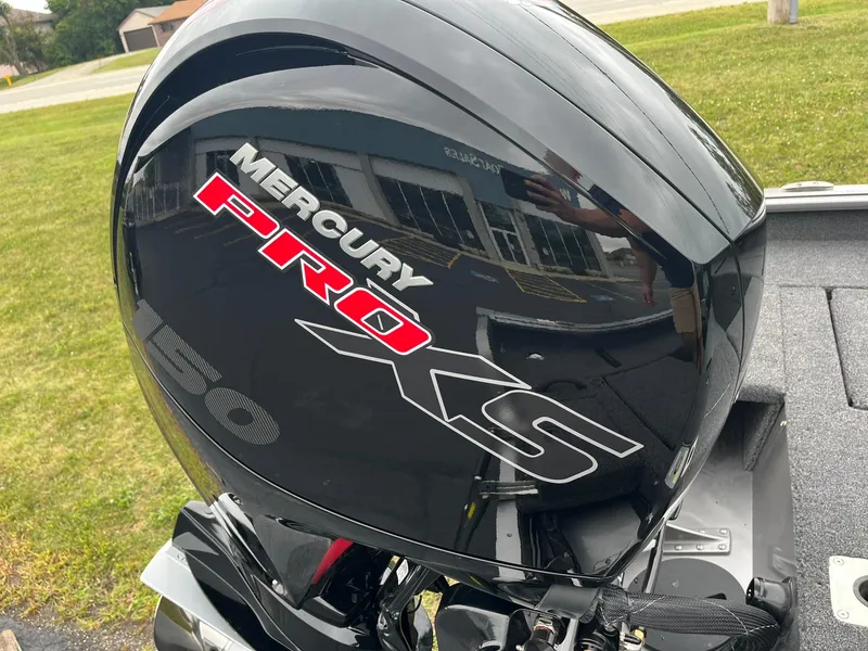 Slide: The Image of Mercury Pro XS engine on 2025 Lund 1875 Impact XS SS boat, parked on grass. - 31