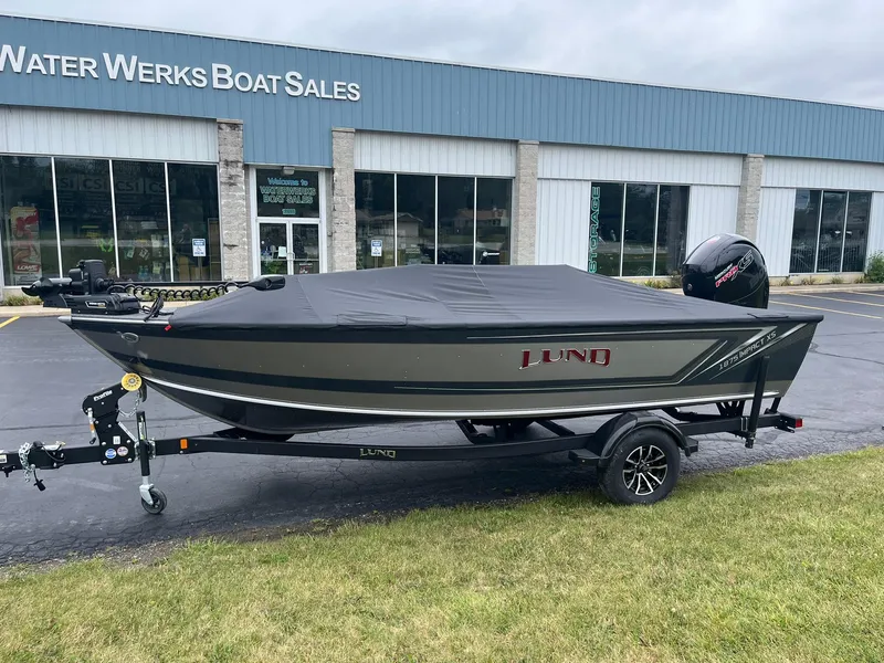 Slide: The Image of 2025 Lund 1875 Impact XS SS boat at dealership, covered and on trailer. - 32