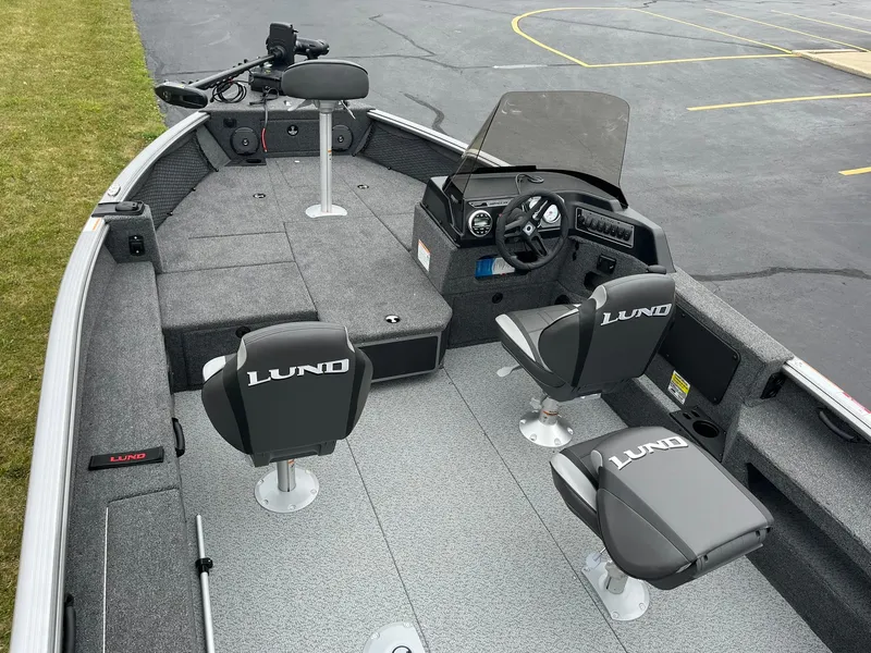 Slide: The Image of 2025 Lund 1875 Impact XS SS boat interior with seating and steering console. - 5