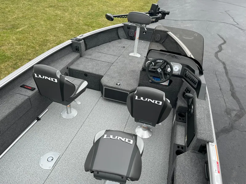 Slide: The Image of 2025 Lund 1875 Impact XS SS fishing boat interior with seating and steering console. - 7