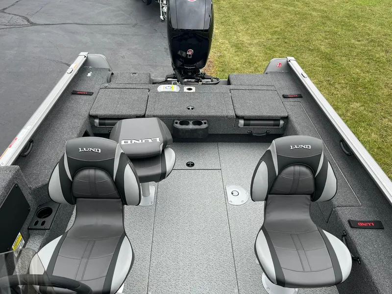 Slide: The Image of 2025 Lund 1875 Impact XS SS boat interior with two gray seats and motor. - 8