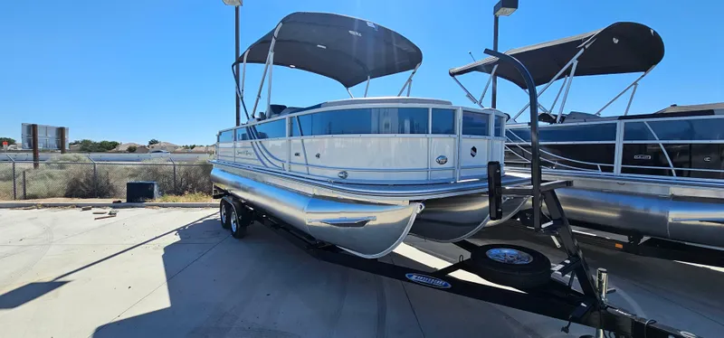 The Image of 2025 South Bay 224FCRLE pontoon boat on a trailer, parked outdoors. - 0