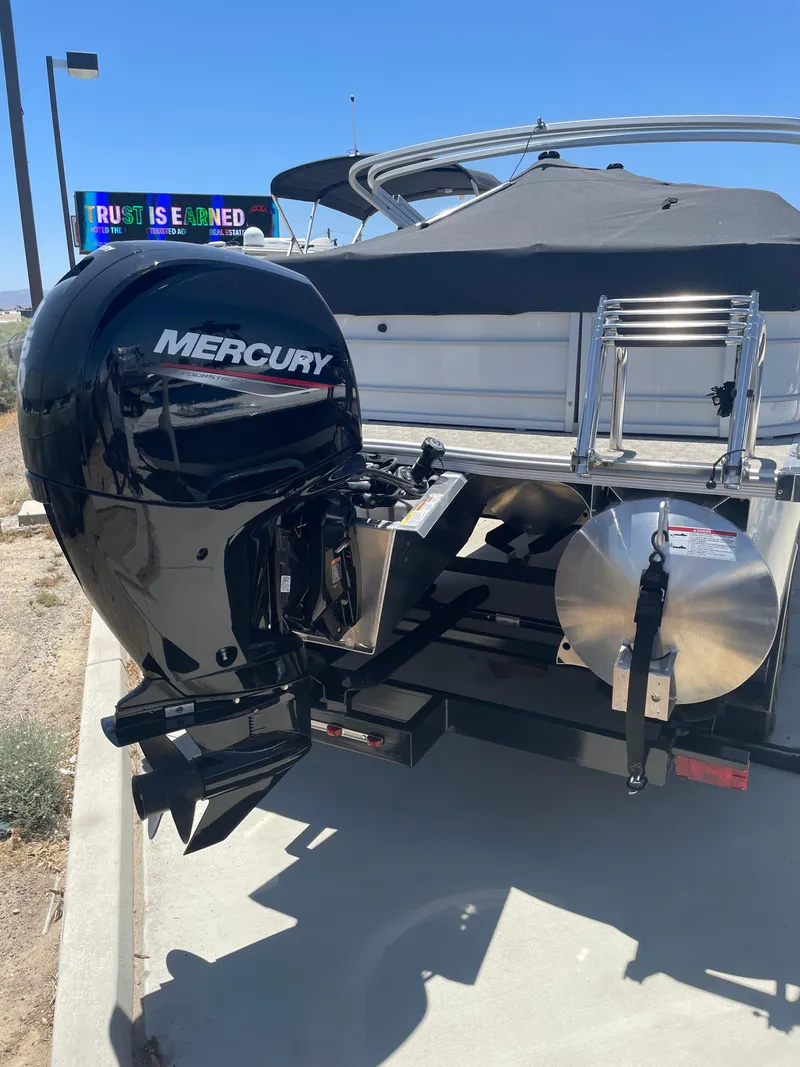 Slide: The Image of 2025 South Bay 224FCRLE boat with Mercury outboard motor, parked on concrete. - 18