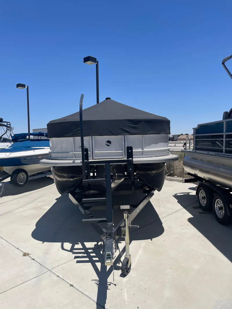 Slide: The Image of 2025 South Bay 224FCRLE pontoon boat on trailer under clear blue sky. - 21