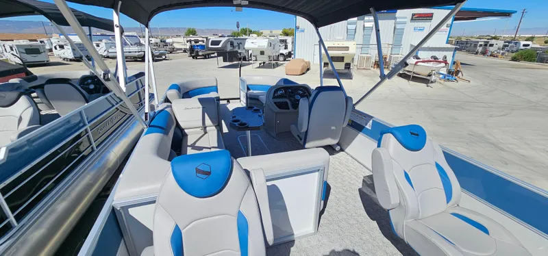 Slide: The Image of 2025 South Bay 224FCRLE pontoon boat with blue and gray seating in a marina. - 8