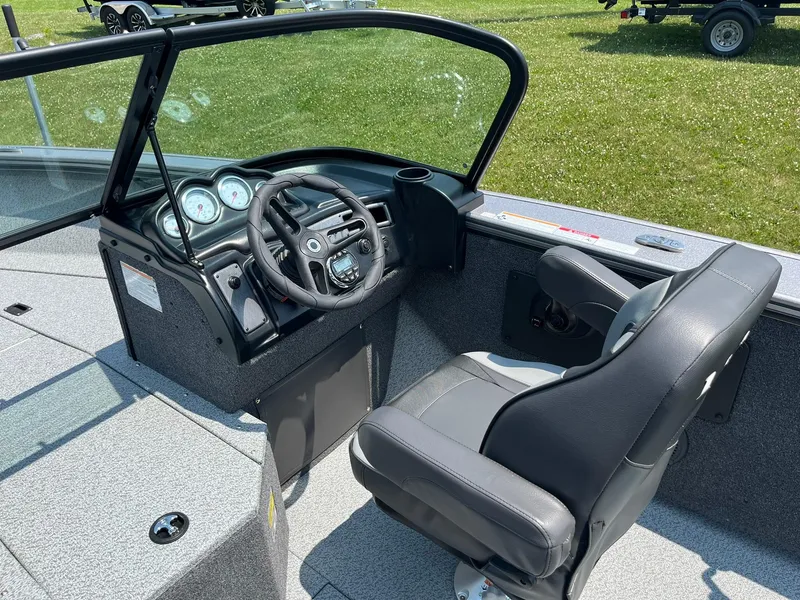 Slide: The Image of 2025 Lund 2075 Fisherman boat cockpit with steering wheel and captain's chair. - 17
