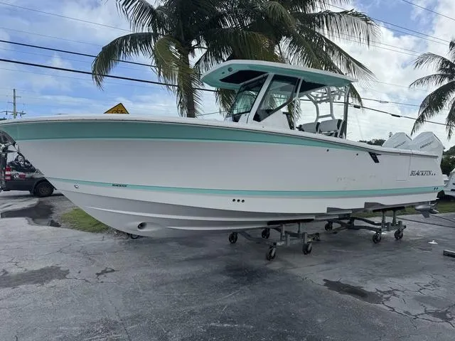 Slide: The Image of 2024 Blackfin 302CC boat cruising on the ocean with fishing rods. - 1