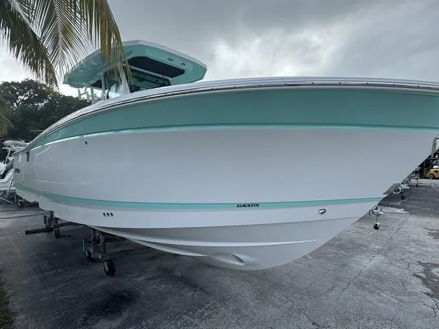 Slide: The Image of 2024 Blackfin 302CC boat cruising on open water. - 2