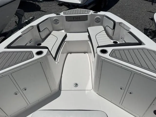 Slide: The Image of 2024 Yamaha Boats 222 FSH Sport E at dealership with jet skis and ATVs. - 9