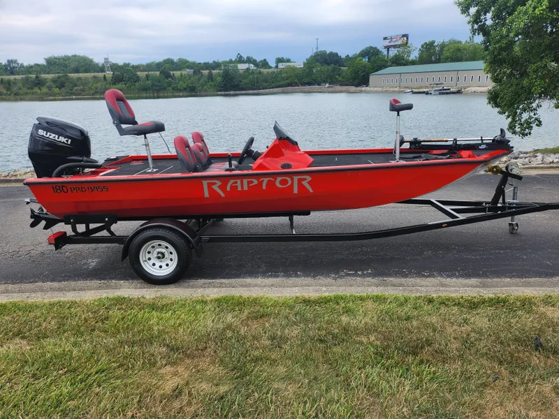 Slide: The Image of 2021 Caravelle Raptor 180 Bass boat on trailer by a lake. - 10