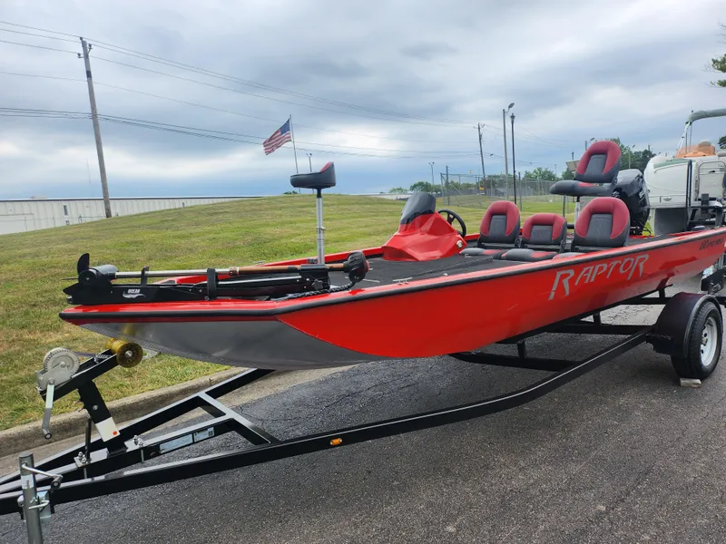 Slide: The Image of 2021 Caravelle Raptor 180 Bass boat in red on a trailer, parked outdoors. - 5