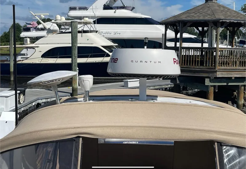 Slide: The Image of 2002 Sea Ray 280 Sundancer docked with other boats in the background. - 10