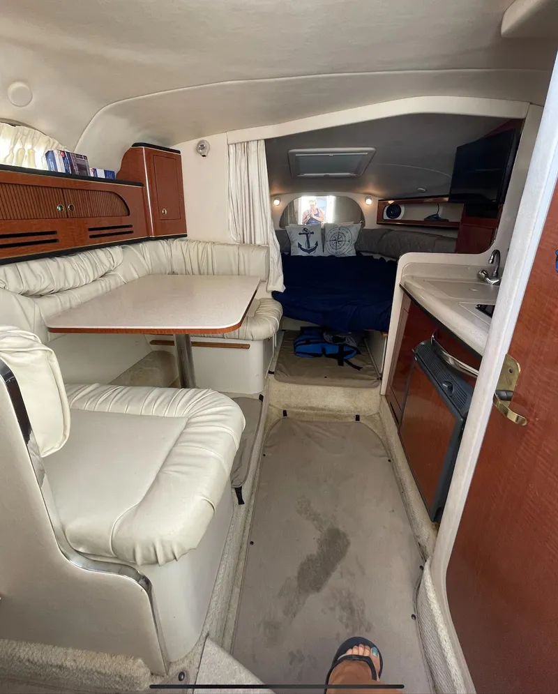 Slide: The Image of 2002 Sea Ray 280 Sundancer cabin interior with dining area and sleeping quarters. - 12