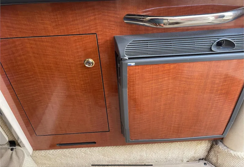 Slide: The Image of 2002 Sea Ray 280 Sundancer cabin interior with wood finish and mini fridge. - 14