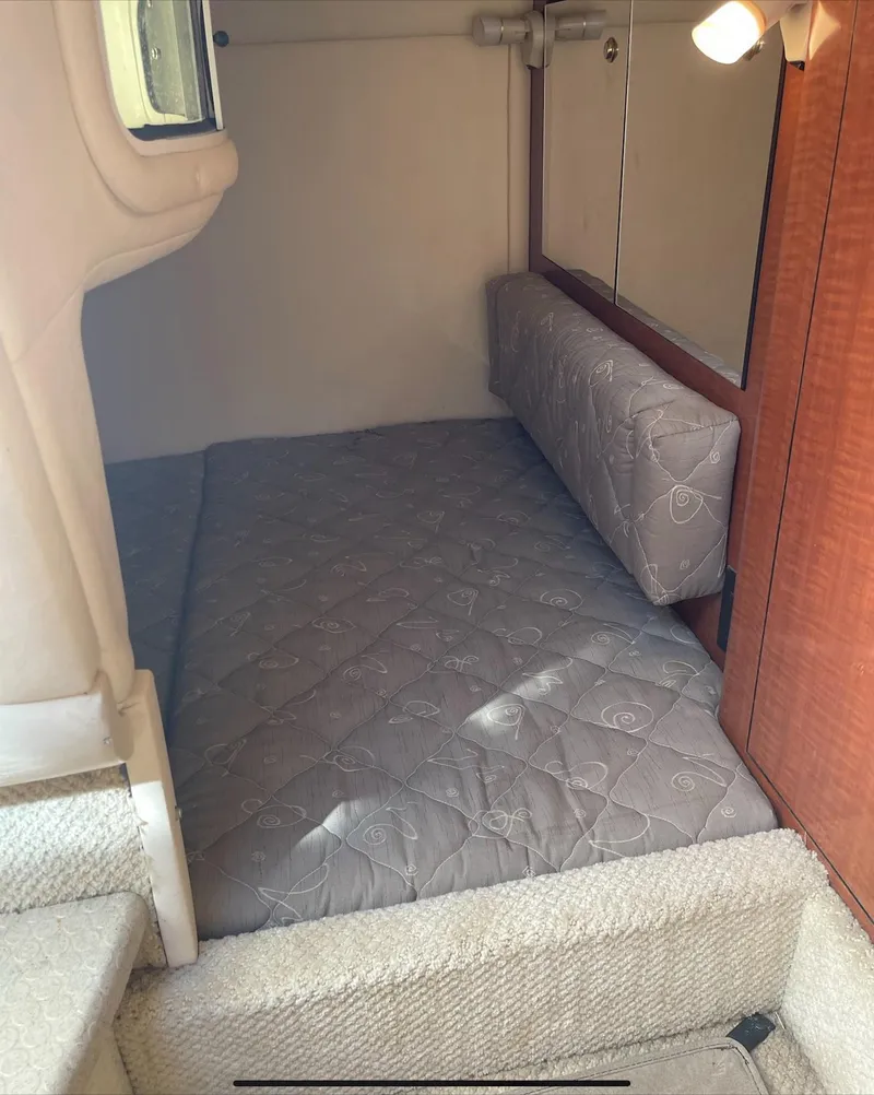 Slide: The Image of 2002 Sea Ray 280 Sundancer cabin interior with bed and lighting. - 18