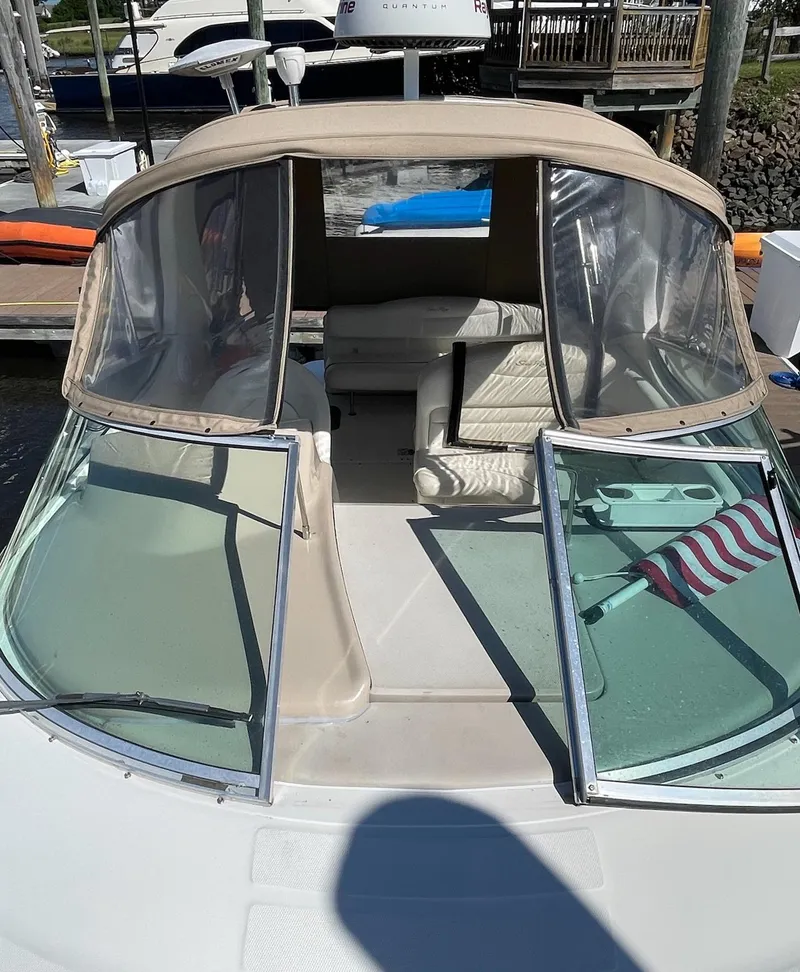 Slide: The Image of 2002 Sea Ray 280 Sundancer boat with open cockpit and American flag. - 2