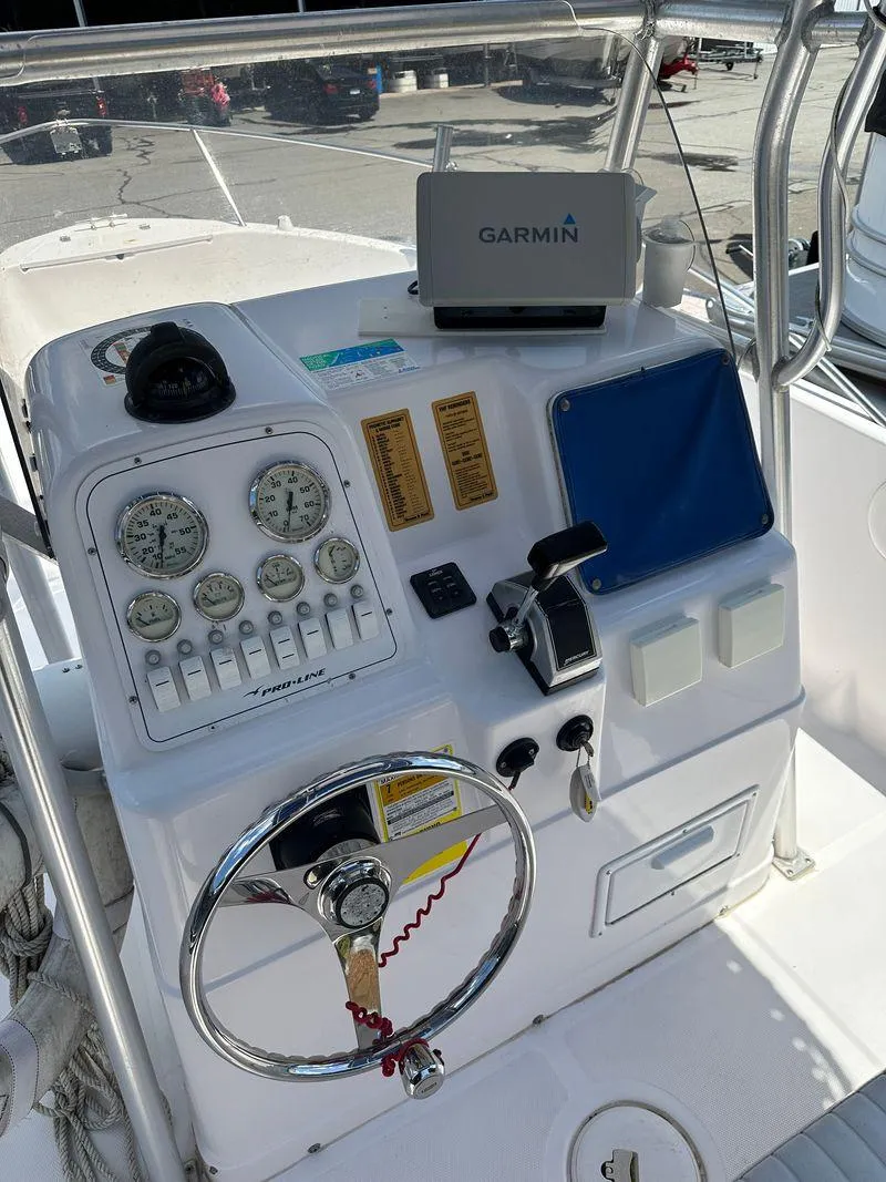 Slide: The Image of 2002 Pro-Line 20 Sport boat dashboard with Garmin GPS and control gauges. - 13