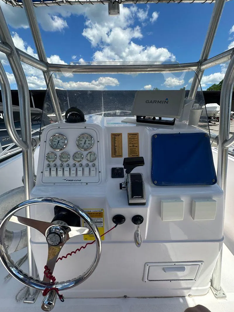 Slide: The Image of 2002 Pro-Line 20 Sport boat dashboard with Garmin navigation system and steering wheel. - 15
