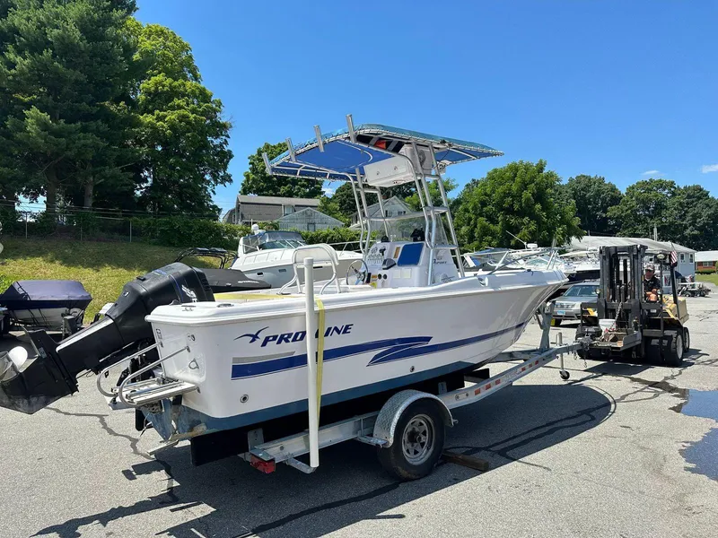 Slide: The Image of 2002 Pro-Line 20 Sport boat on a trailer in a parking lot. - 2