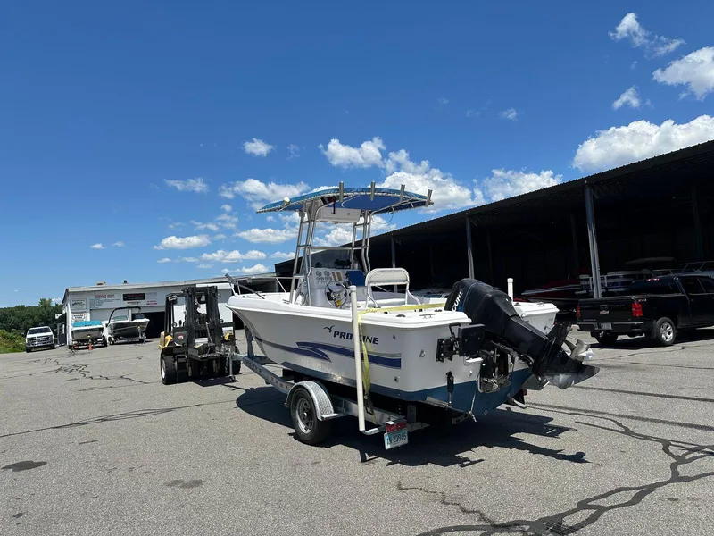 Slide: The Image of 2002 Pro-Line 20 Sport boat on trailer in parking lot under clear sky. - 5
