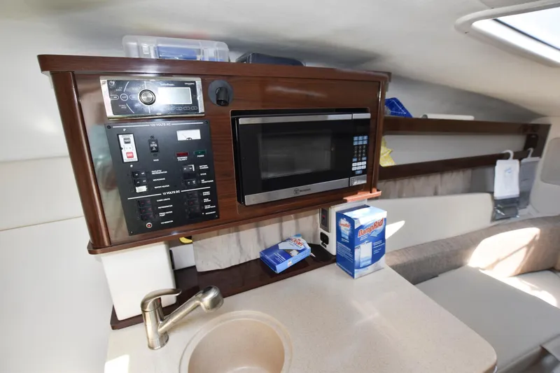 Slide: The Image of 2015 Sea Ray 260 Sundancer cabin kitchen with microwave and sink. - 11