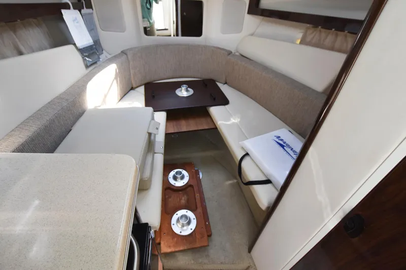 Slide: The Image of Interior cabin of 2015 Sea Ray 260 Sundancer with beige seating and table. - 12