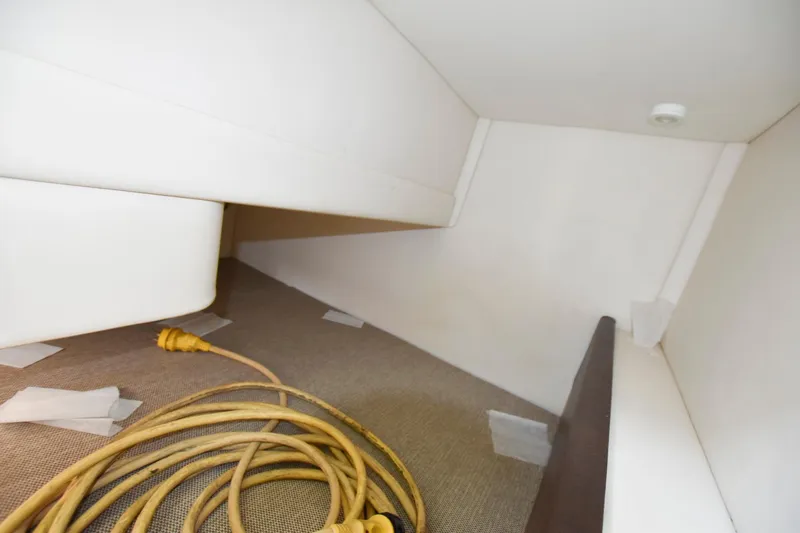 Slide: The Image of Interior cabin of 2015 Sea Ray 260 Sundancer with storage space and electrical cords. - 14